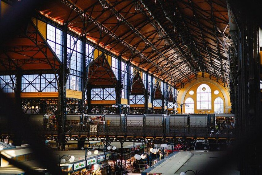 A large indoor train station with high ceilings, large windows, and multiple platforms. 2