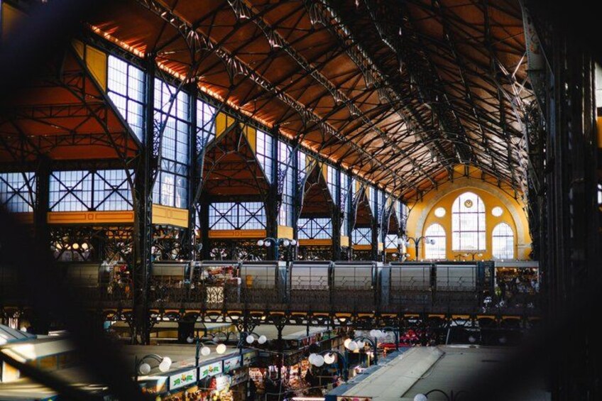 A large indoor space with high ceilings, large windows, and a central open area with tables and chairs. 2