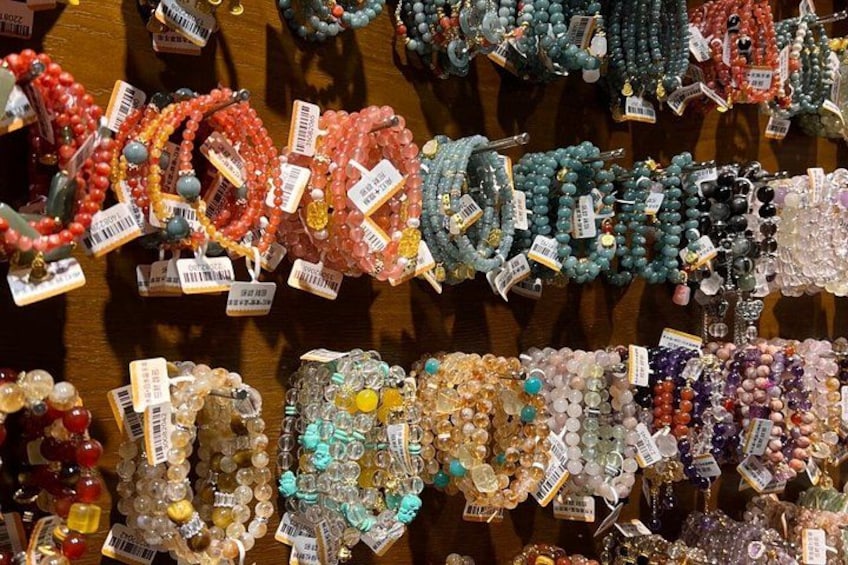 A variety of colorful beaded bracelets displayed on a wooden surface. 1