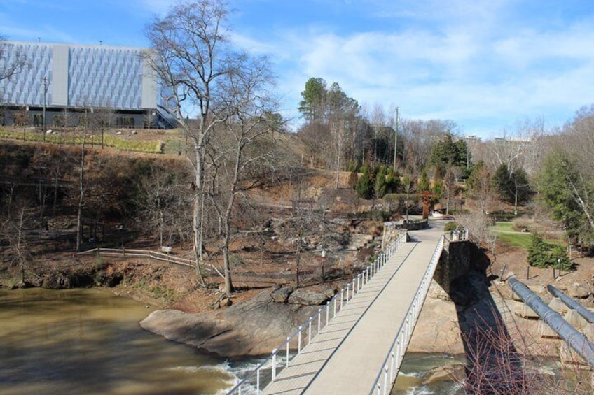 A dam with a bridge, a river, and a building in the background. 2