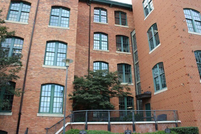 A red brick building with multiple windows and a metal railing. 3