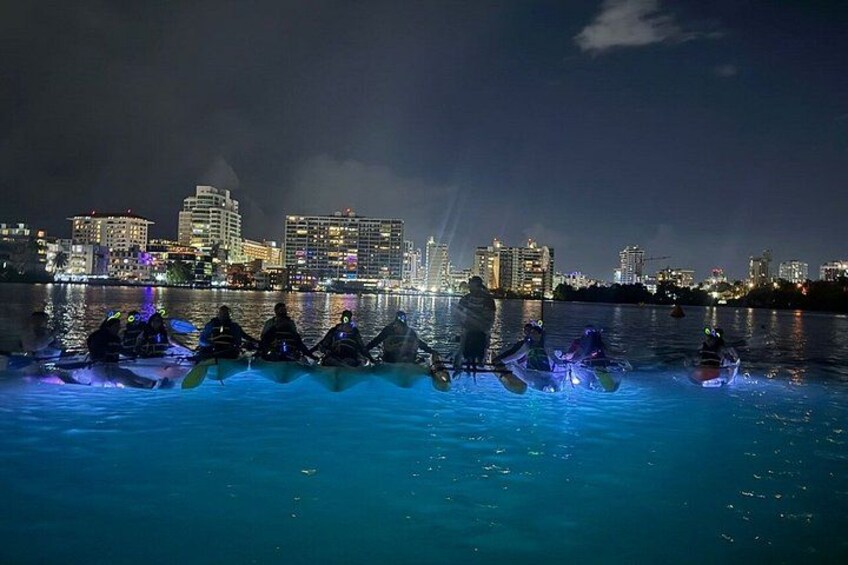 A nighttime scene with people on watercraft in a city skyline background. 2