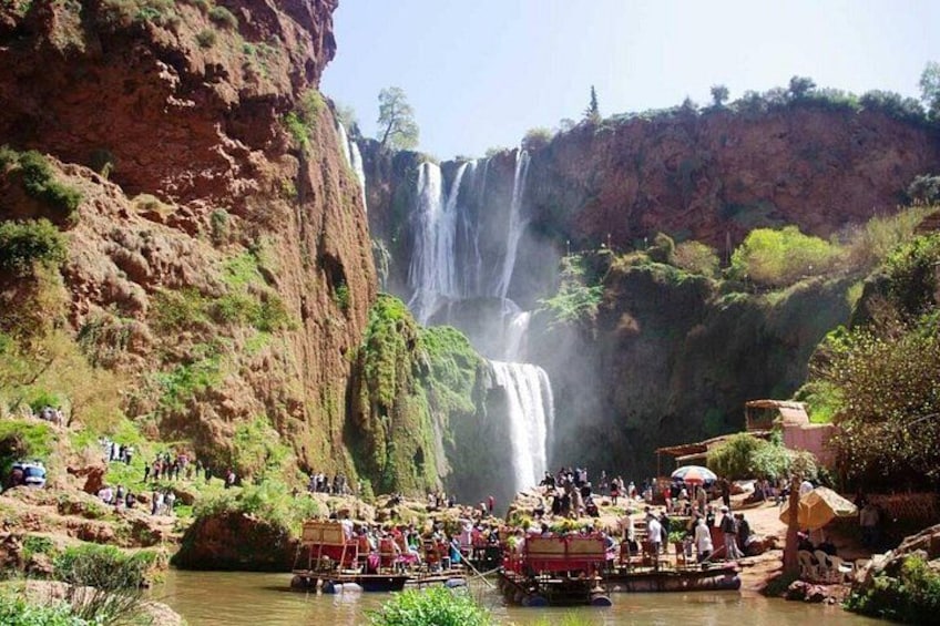 A waterfall, a river, and people on a boat. 3