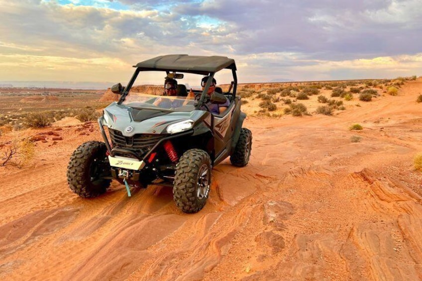 A black off-road vehicle on a desert terrain with sparse vegetation. 2