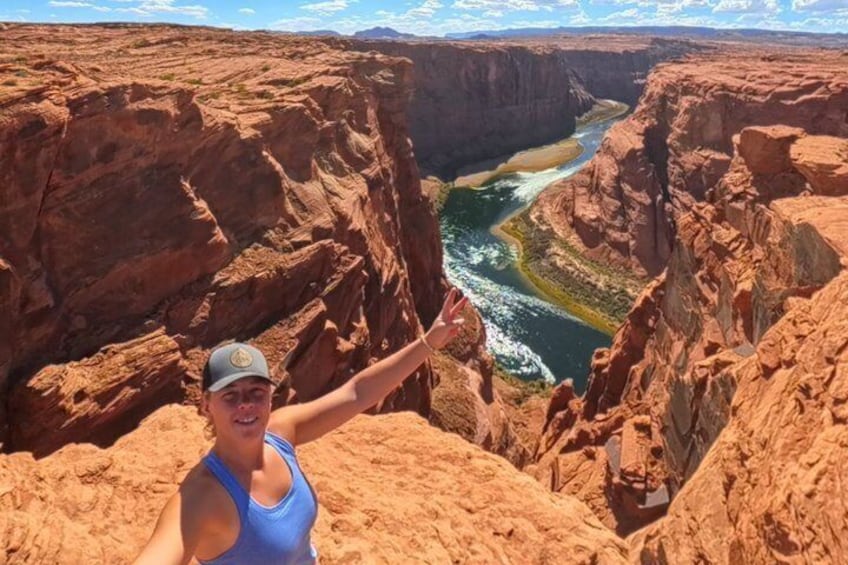 A person standing on a cliff overlooking a canyon with a river. 4