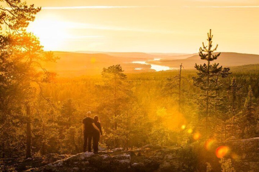 A couple hiking in a forest with a sunset in the background. 1
