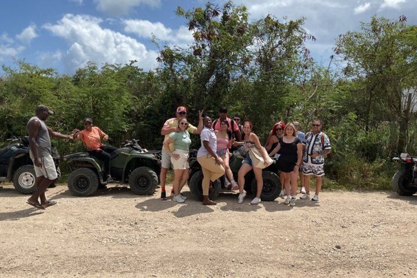 A group of people on ATVs in a natural setting with trees and dirt ground. 3