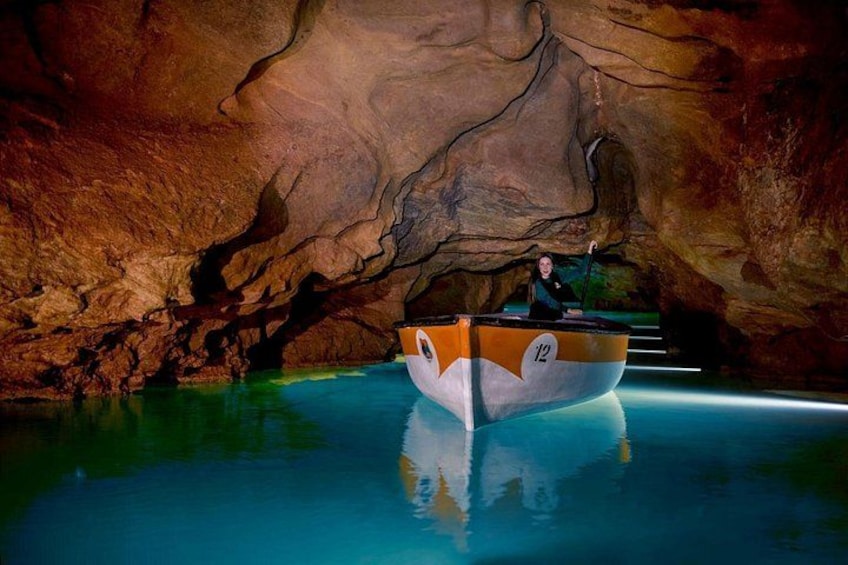 A boat with the number 12 on it, floating in a cave with water. 3