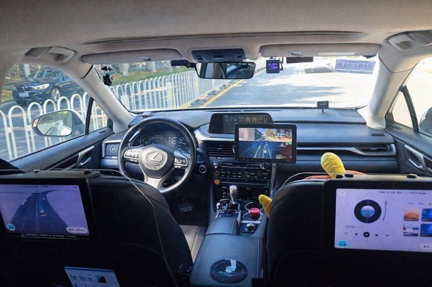 A car interior with a steering wheel, dashboard, and a screen displaying a road map. 4