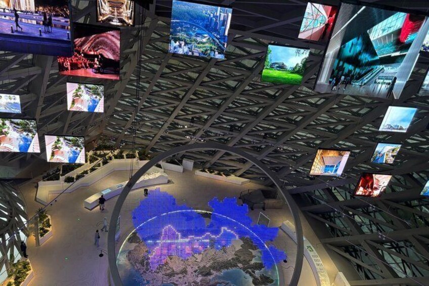 A modern building with a curved ceiling displaying multiple screens. 3