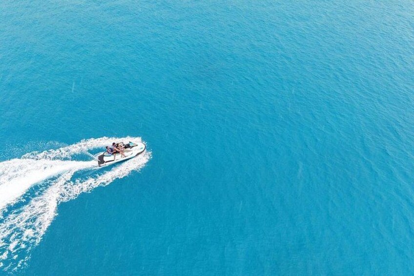 A jet ski moving across a calm blue body of water. 2