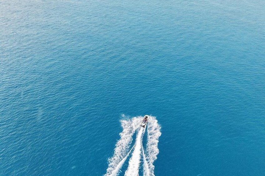 A boat creating a wake in a large body of water. 4