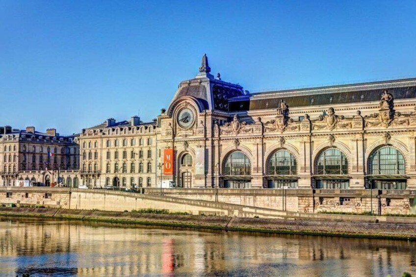 A historic train station with arched windows and a prominent clock tower. 2