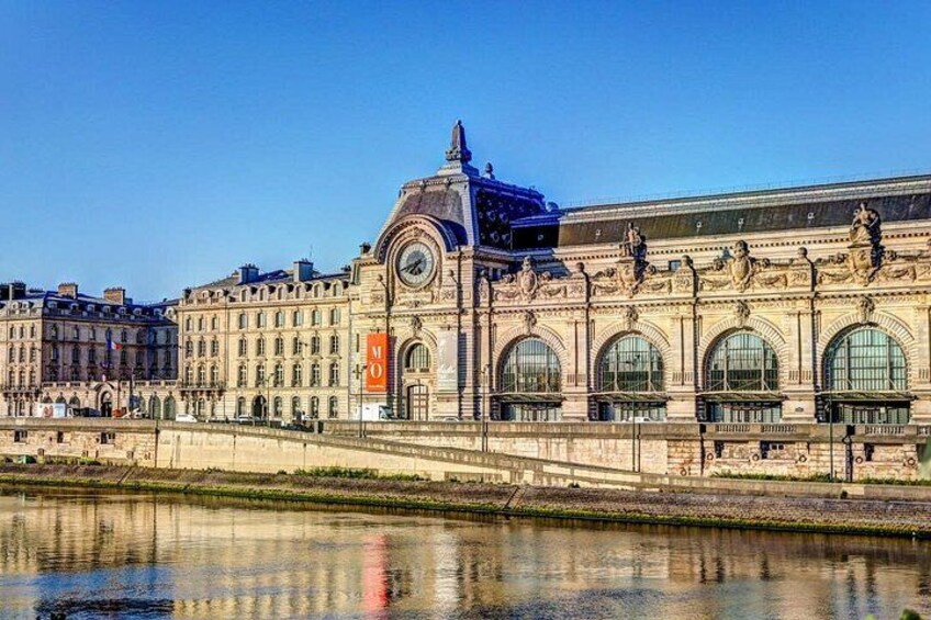 A historic building with arched windows and a dome, reflecting in a body of water. 2
