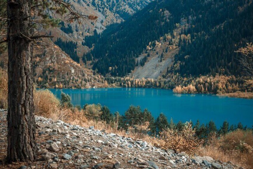 A mountain lake surrounded by trees and rocky terrain. 1