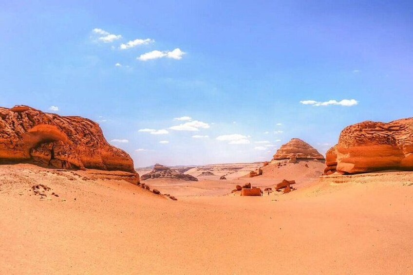 A desert landscape with prominent rock formations and a clear sky. 4
