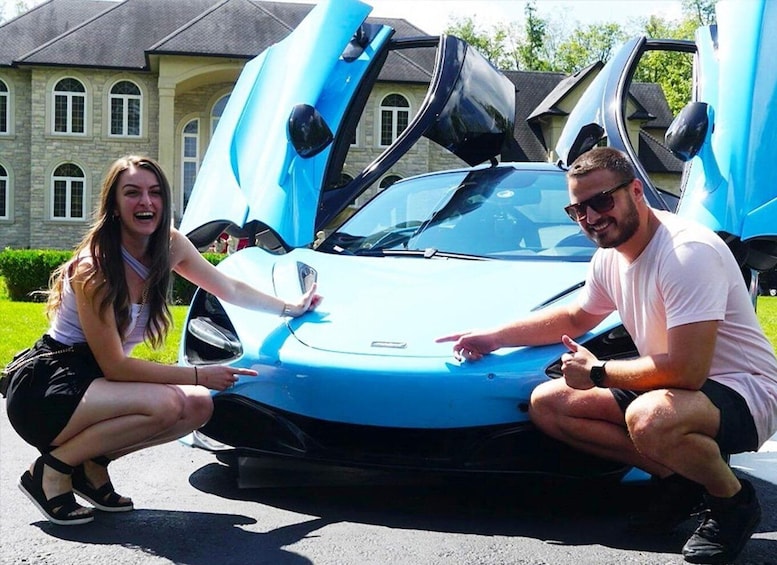 A blue sports car with its doors open, parked in front of a stone building. 5
