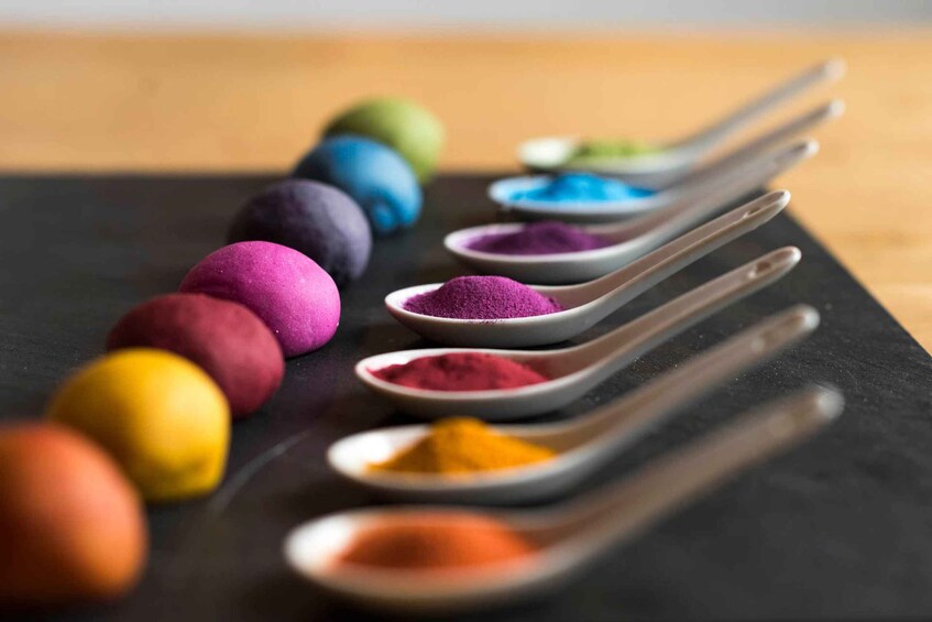 A variety of colorful powders arranged on spoons and in bowls. 1