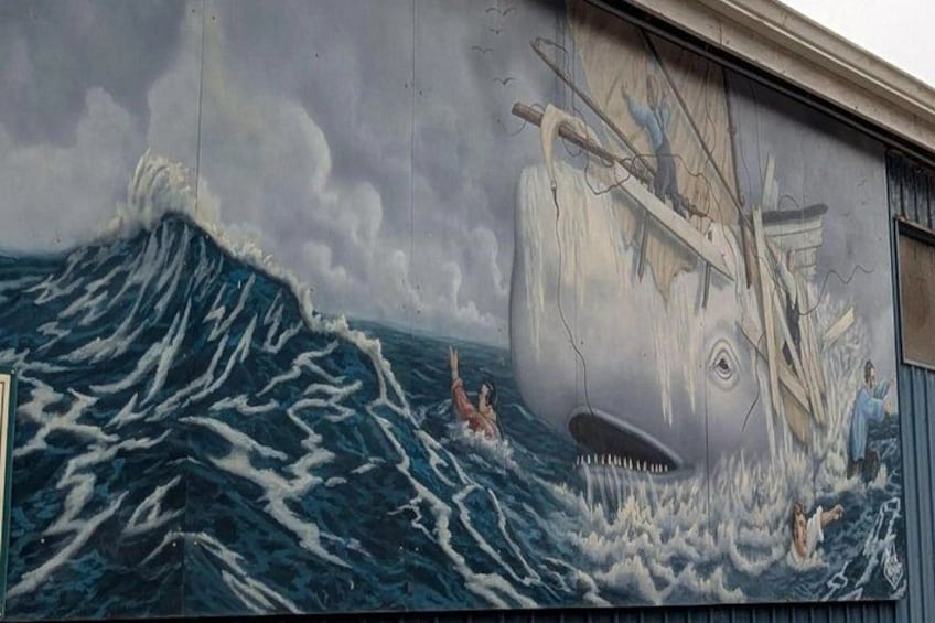 A mural of a large whale and a ship in the ocean. 4