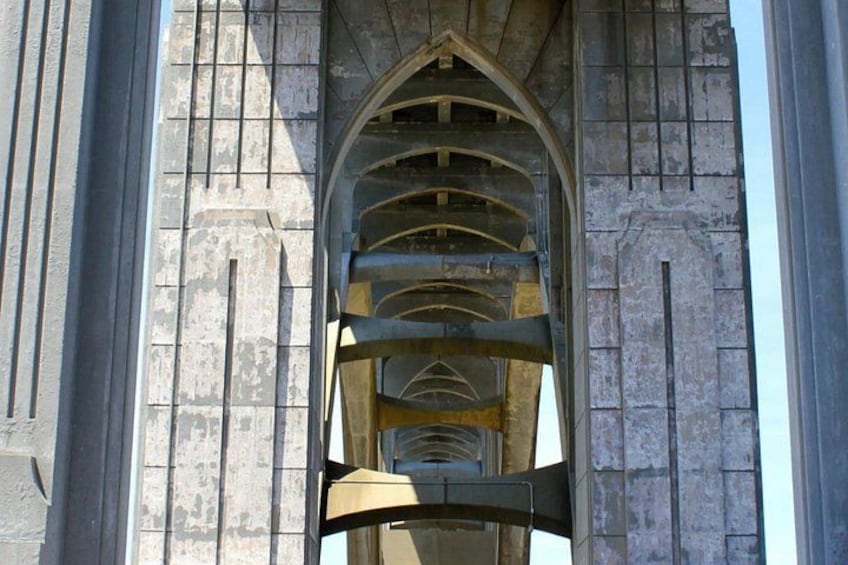 A stone bridge with a series of arches and a metal railing. 5