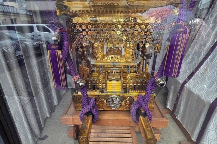 A golden altar with purple tassels, surrounded by intricate decorations and a wooden base. 2
