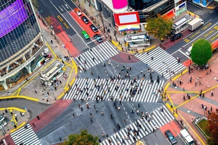 An urban intersection with crosswalks, vehicles, and pedestrians. 1