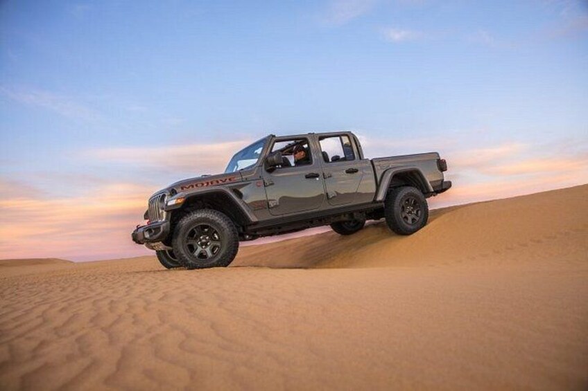A vehicle on a sandy terrain with a clear sky. 2