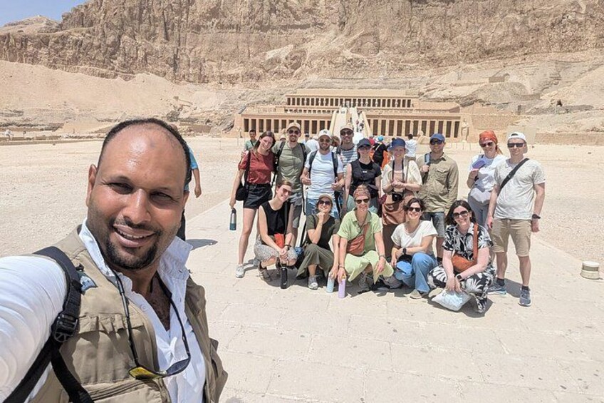 A group of people in a desert landscape with ancient ruins in the background. 3