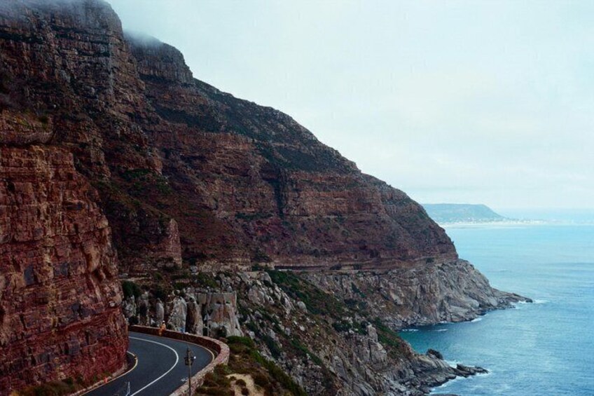 A coastal road winding along a steep cliffside with a view of the ocean. 2