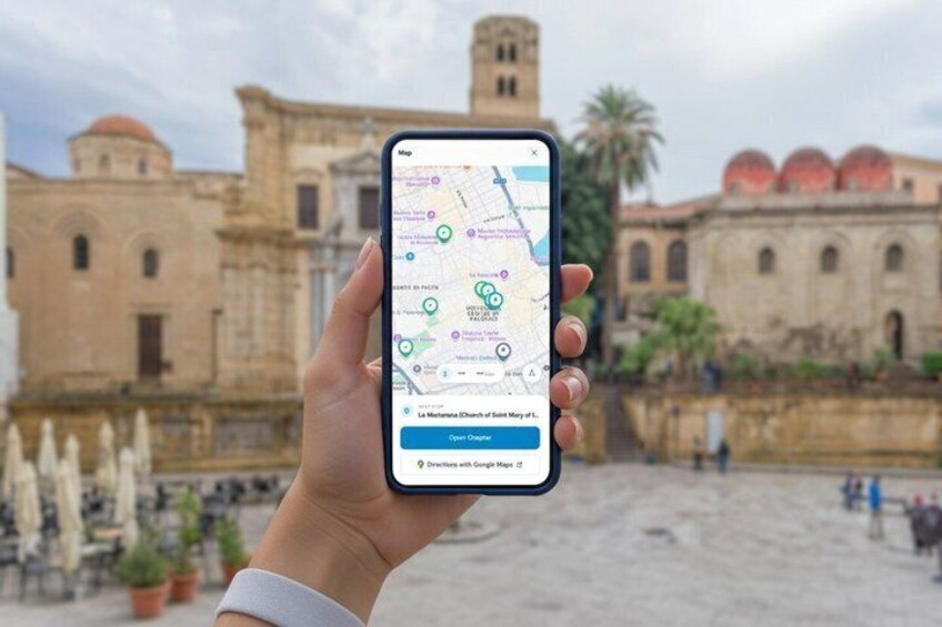 A hand holding a smartphone with a map application, displaying a location with a historical building in the background. 2