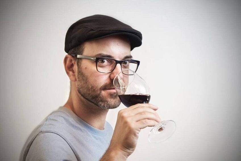 A person wearing a cap and glasses holding a wine glass. 2