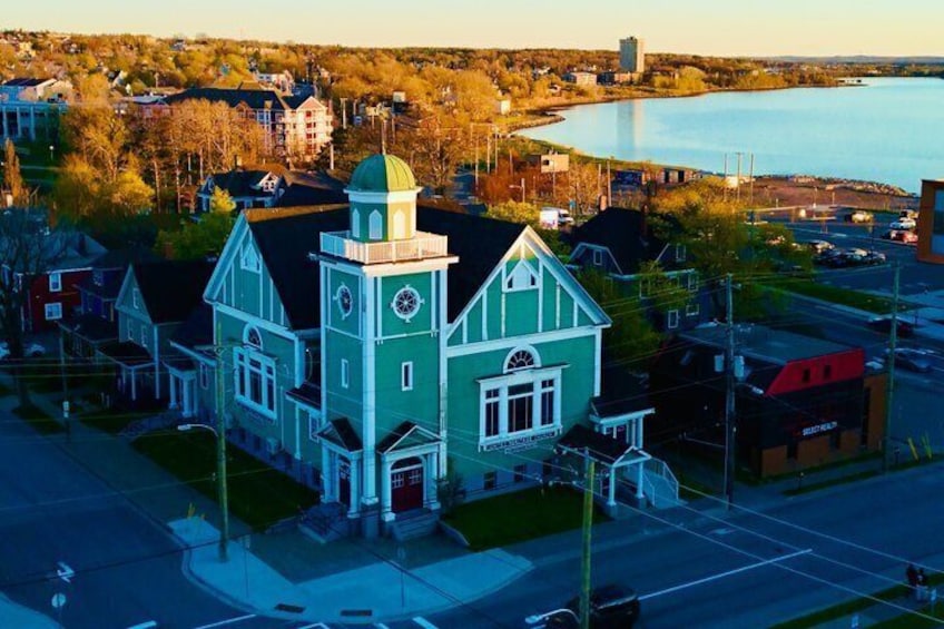 A church with a green and white facade, a clock tower, and a lake in the background. 5