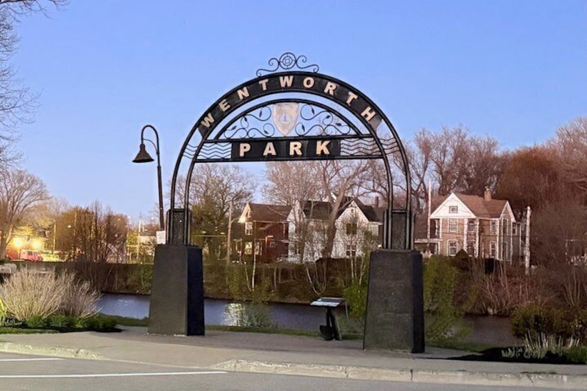 A wrought iron gate with 'Wentworth Park' written above it, surrounded by trees and a building in the background. 4