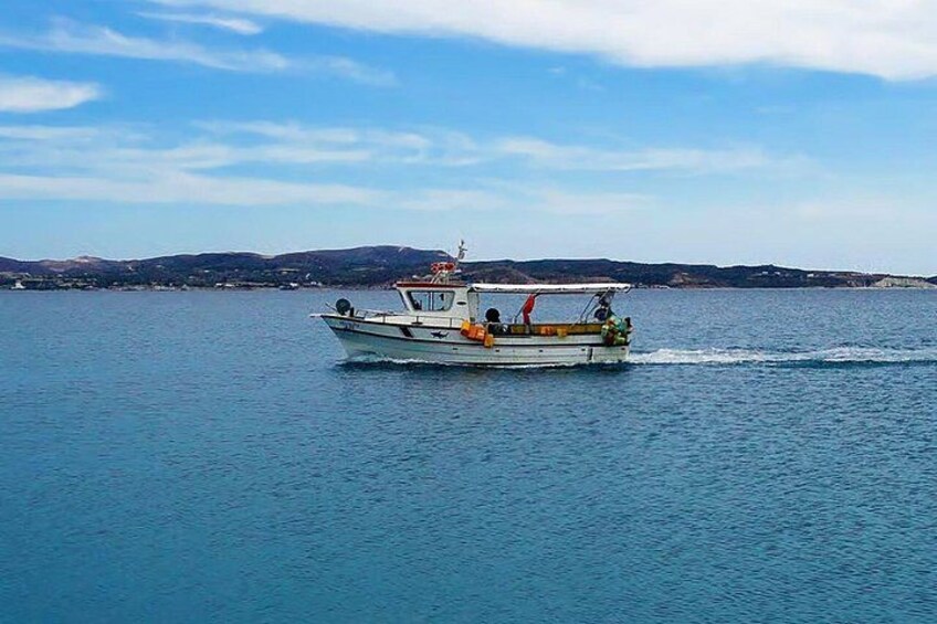 A small boat on calm water with a hilly landscape in the background. 2
