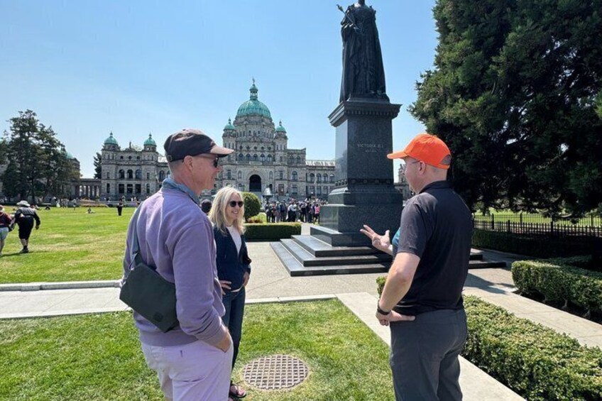 A group of people standing in a park with a large building and a monument in the background. 4