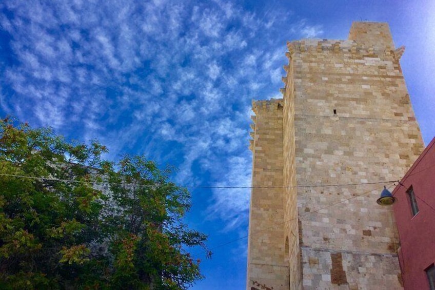 A tall stone tower with a clear blue sky and some clouds in the background. 3