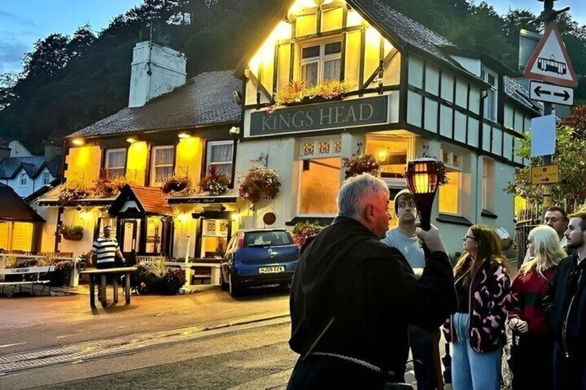 A pub named 'Kings Head' with outdoor seating and a signboard. 2