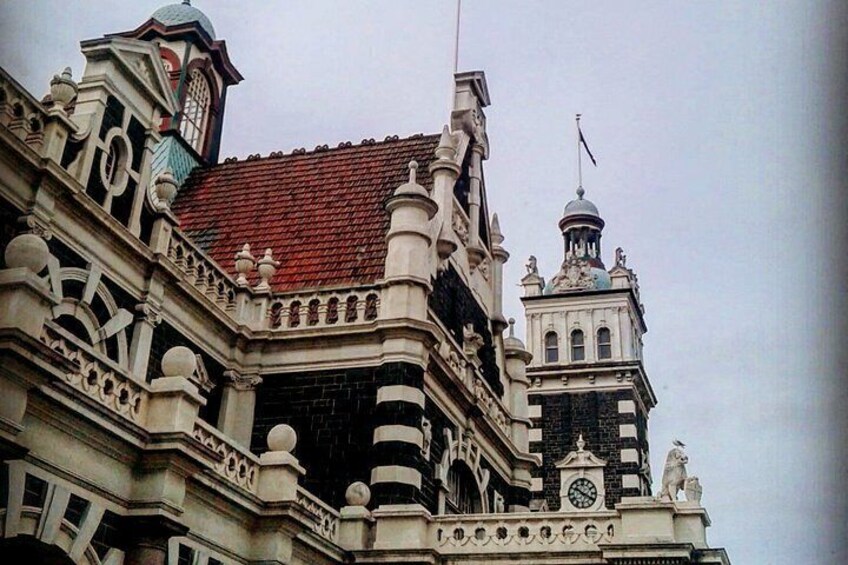 A building with ornate architectural details, including a clock tower and decorative statues. 2