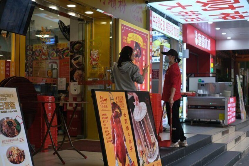 A food stall with a menu board and a person standing at the counter. 4