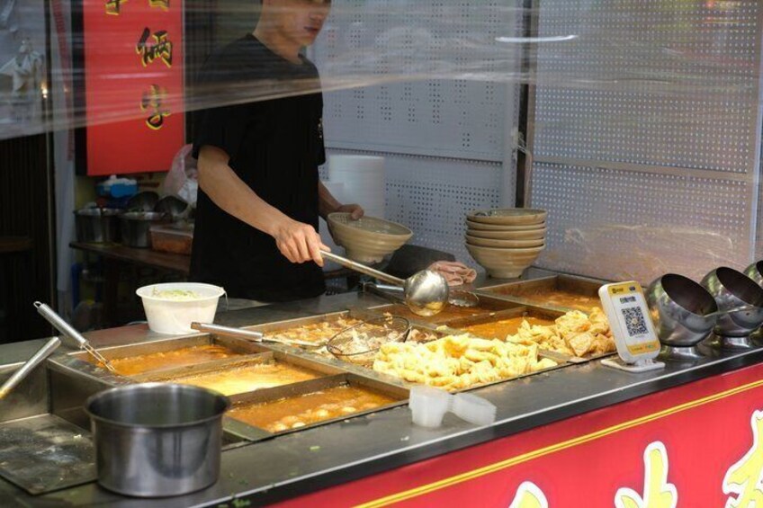 A food stall with various dishes and cooking utensils. 3