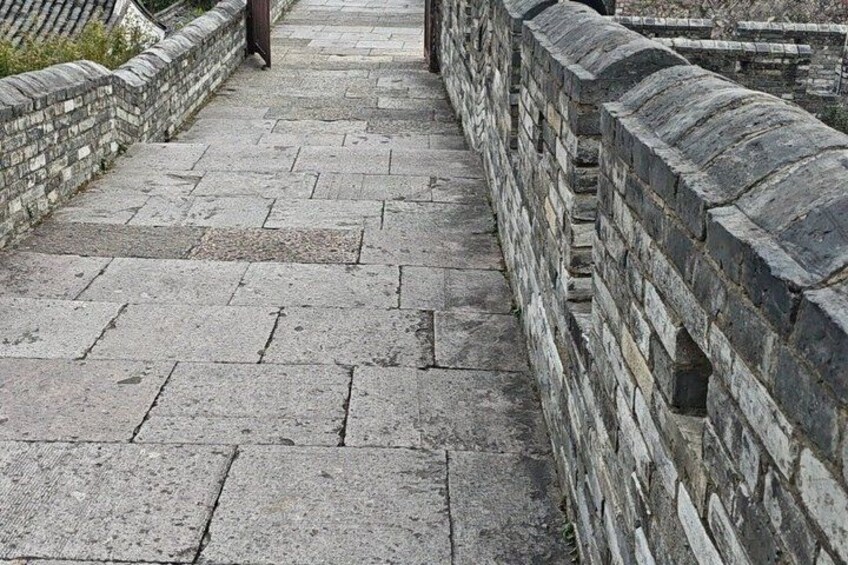 A stone pathway with a stone wall on one side. 5