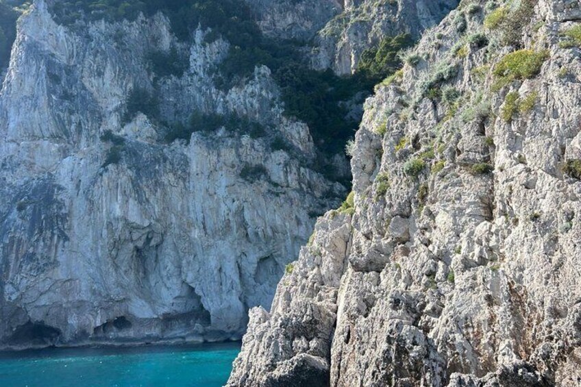 A rugged coastline with steep cliffs and a turquoise sea. 2