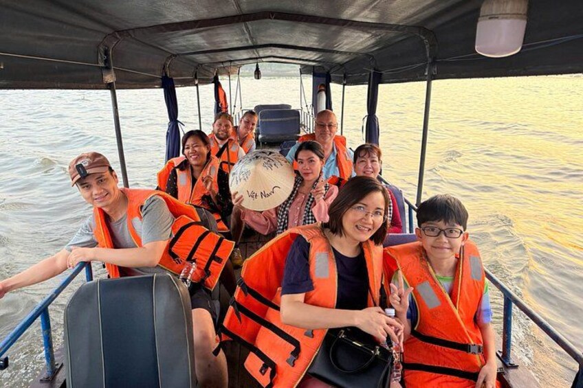 A group of people on a boat wearing life jackets. 1