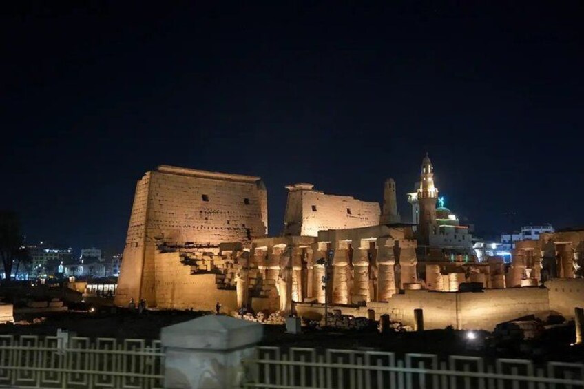 Ancient ruins at night with illuminated structures. 2