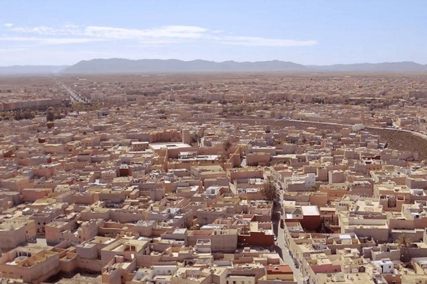 A sprawling urban landscape with densely packed buildings and a clear sky. 3