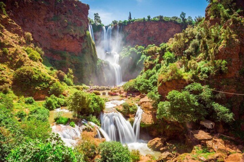 A waterfall cascading down a cliff surrounded by lush greenery. 5