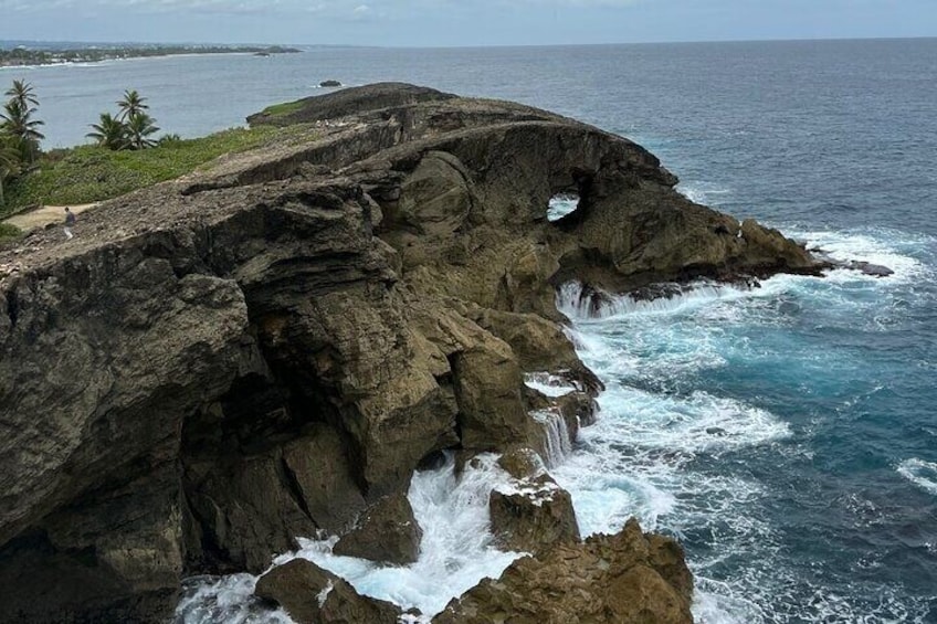 A rugged coastline with a waterfall cascading down a rocky cliff into the ocean. 3