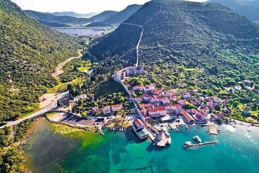 A coastal town with a harbor, surrounded by hills and a river. 4