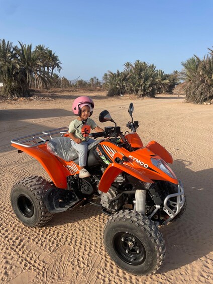 A person on a Kymco ATV in a desert with sparse vegetation. 4
