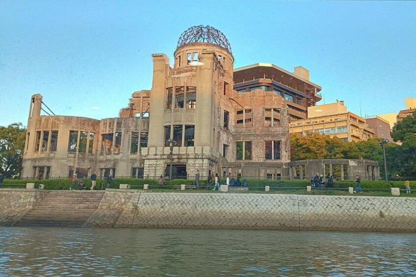 Un bâtiment historique doté d’un dôme et de nombreuses fenêtres, situé au bord d’un plan d’eau. 1
